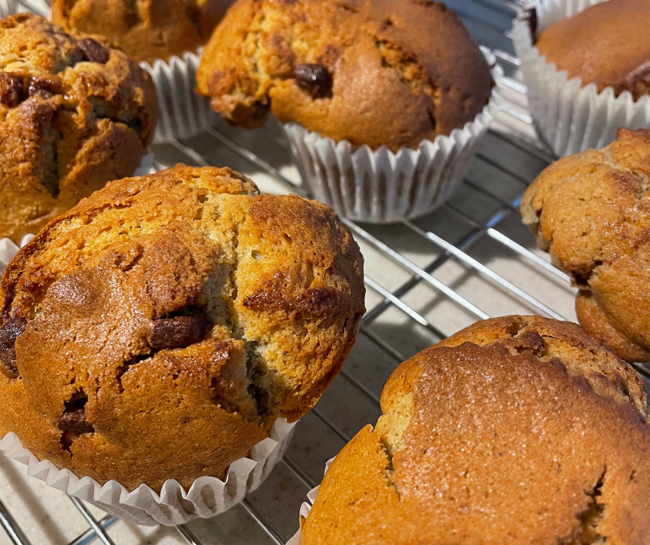 A close up of chocolate chip muffins cooling down on a wired rack