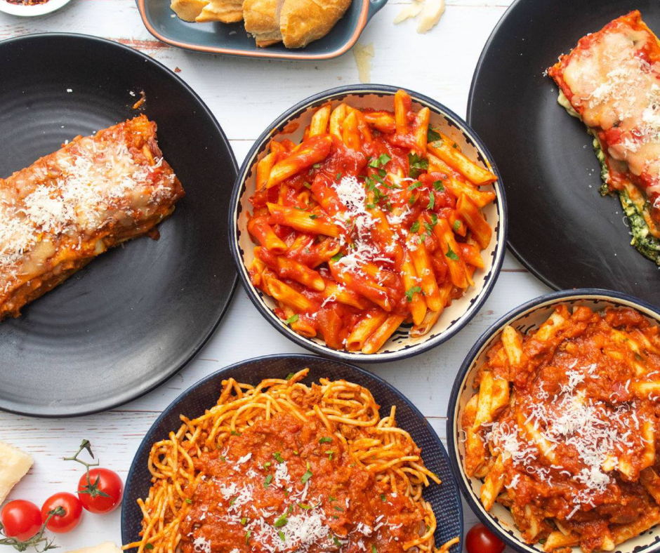 A selection of pasta dishes laid out on a dining table