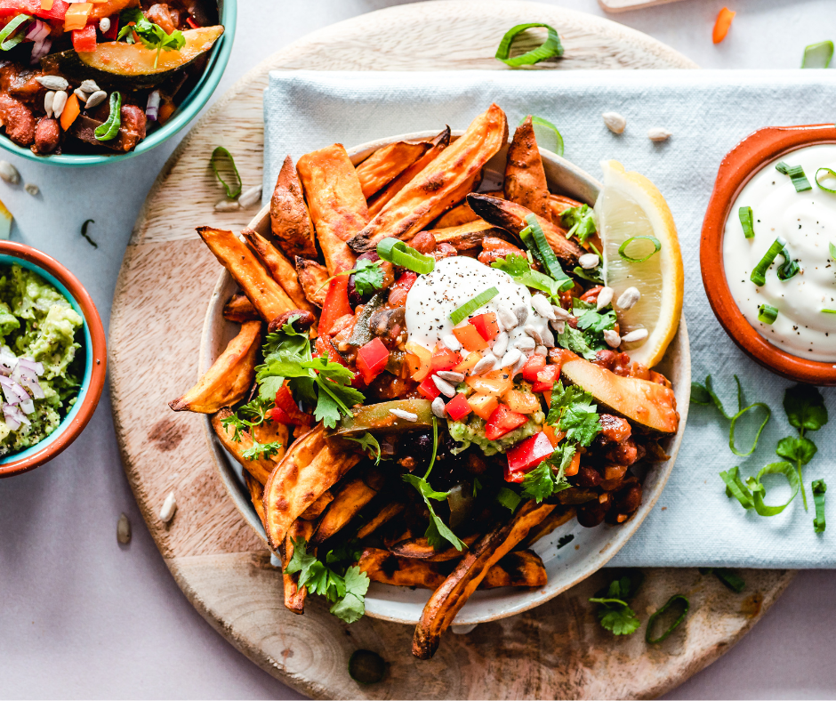 A plate of sweet potato fries with sour cream and guacomole dip